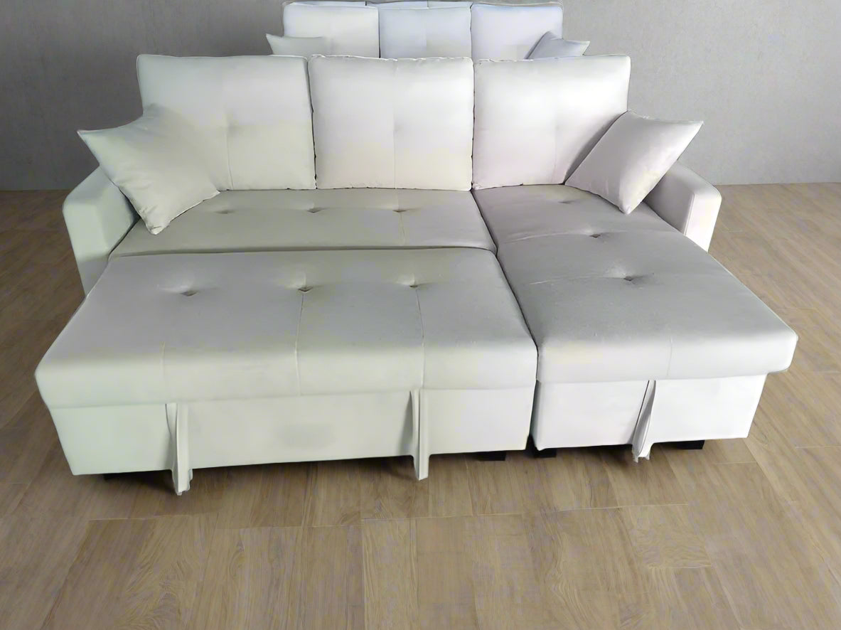 Beige sectional sofa with storage ottoman on a green floor.