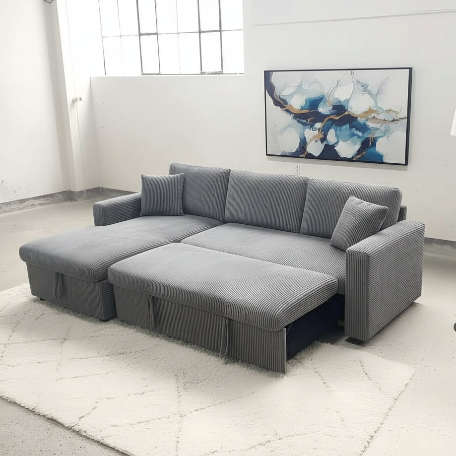 Dark grey sectional sofa with storage drawers in a room with a rug, lamp, and abstract painting.