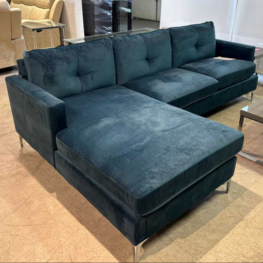 Blue sectional sofa in a showroom setting with other furniture.