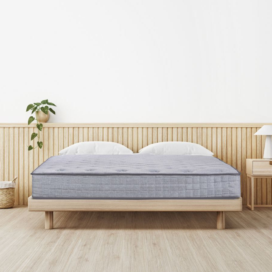 Mattress on a wooden bed frame in a minimalistic bedroom setting