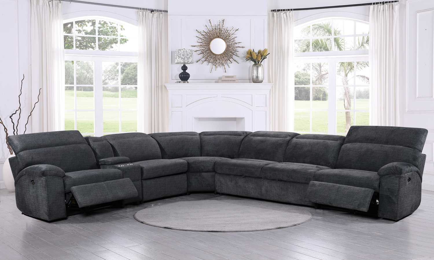 A charcoal grey woven fabric sectional sofa with multiple seats, including a left-hand facing loveseat and a right-hand facing chaise, arranged in a circular configuration in a room with a windows and a light interior.