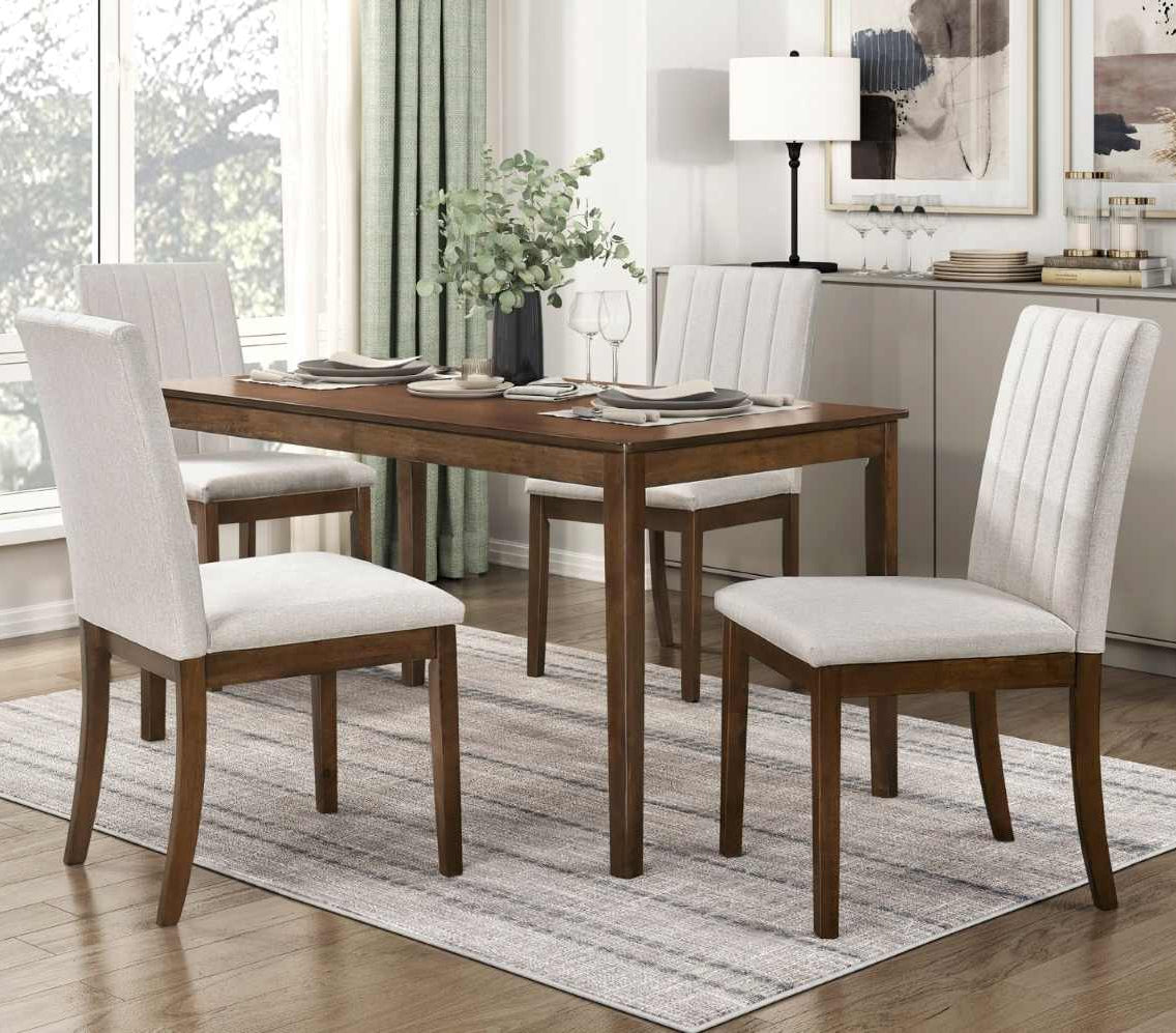 Dining room with wooden table and chairs on a rug, large window, and decor.
