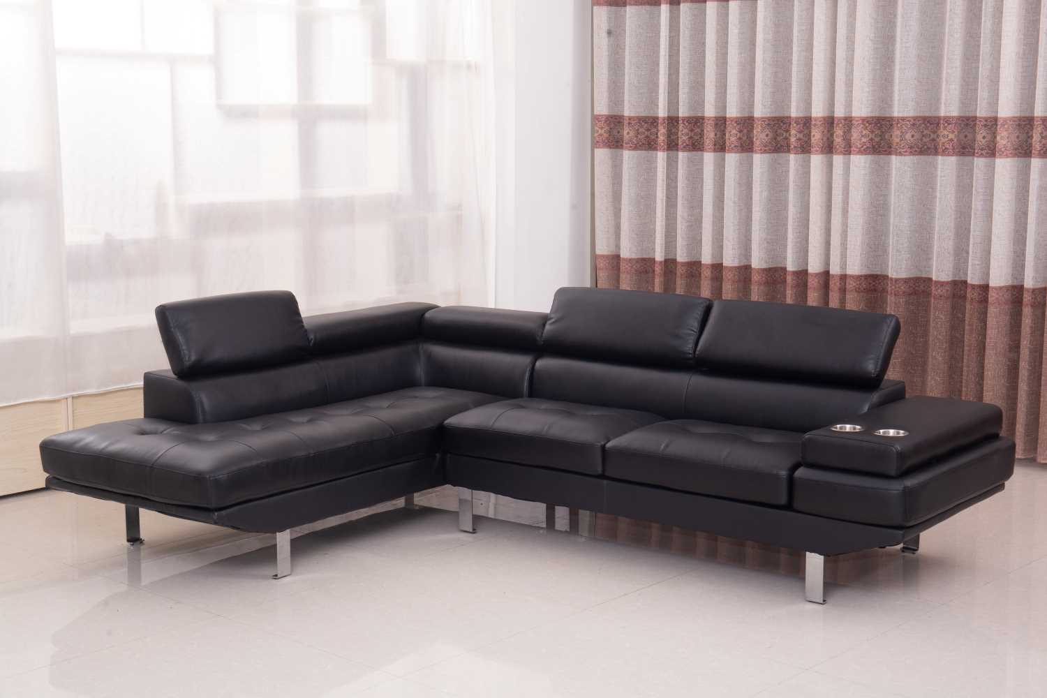 Black air leather sectional sofa with a modern sleek design, positioned in a cozy living room setting.