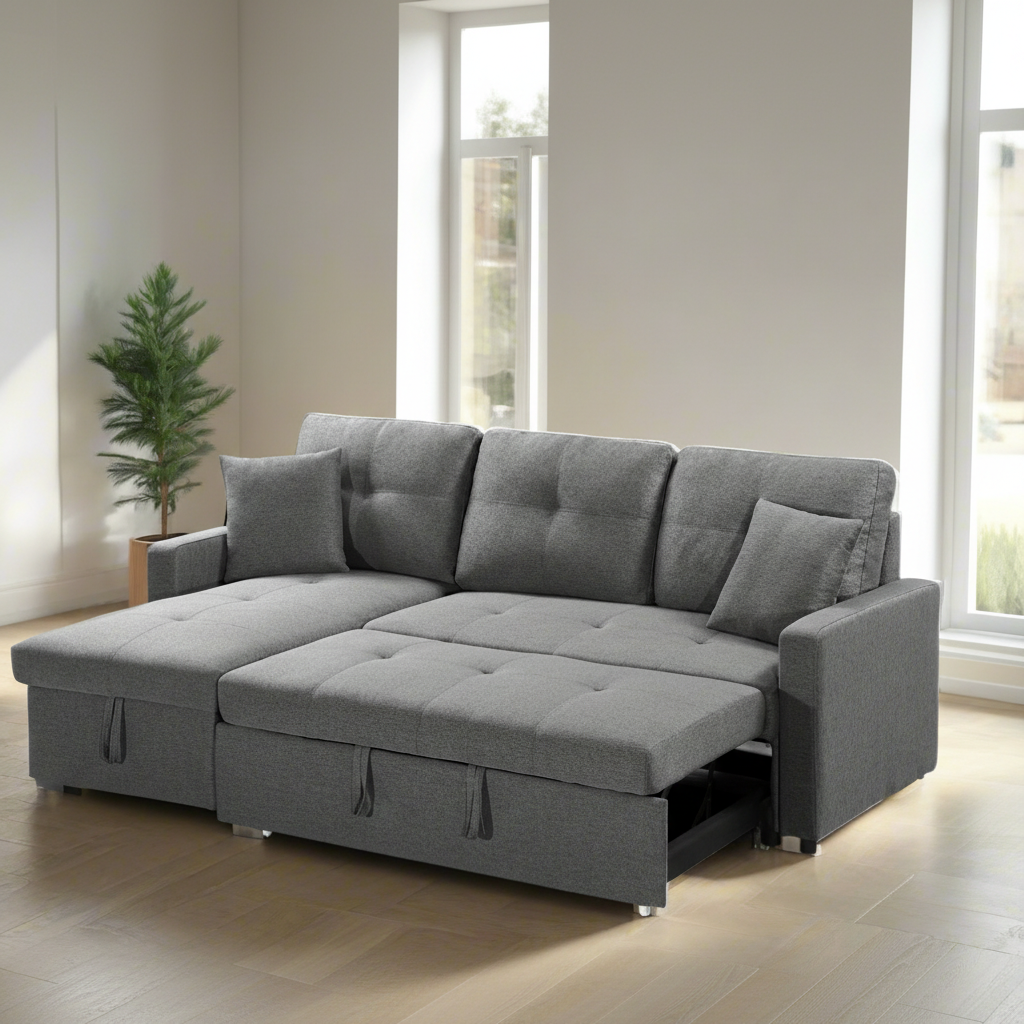 A gray fabric reversible pull-out sectional sofa bed with storage compartment, displayed in a room setting with a plant and window in the background.