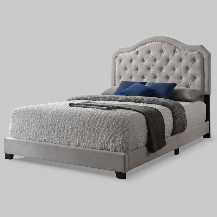 Gray upholstered bed with tufted headboard and bedding on a light gray background