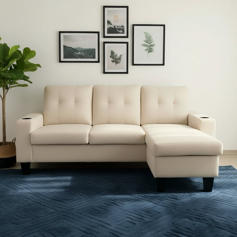 Beige sectional sofa in a living room with a wooden coffee table, blue rug, and framed pictures on the wall.